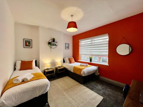克利索普斯Daubney House - Great for Contractors or Family Holidays的一间卧室设有两张床和红色的墙壁