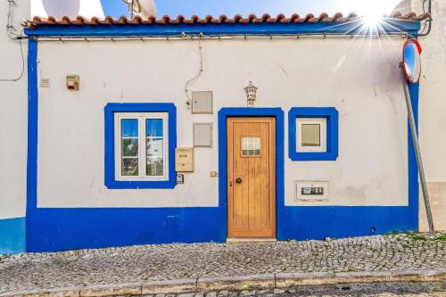 卡武埃鲁Casa Perola -ocean view cottage的蓝色和白色的房子,设有木门