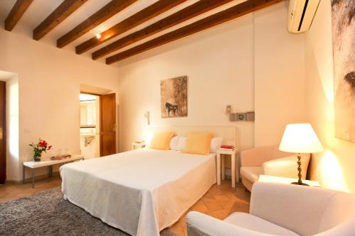 福纳卢奇Fornalutx Petit Hotel - Bed & Breakfast的卧室配有一张白色的大床和一张沙发。