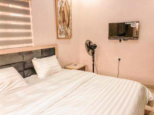 伊凯贾Crayford Homes的卧室配有白色的床和风扇