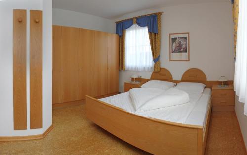 拉塞斯Mühlrast的一间卧室配有一张带白色床单的大床