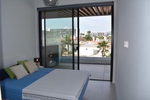 多列毛利诺斯Luxury complex beachfront apartment with gym and large terrace的一间卧室设有一张床和一个大窗户