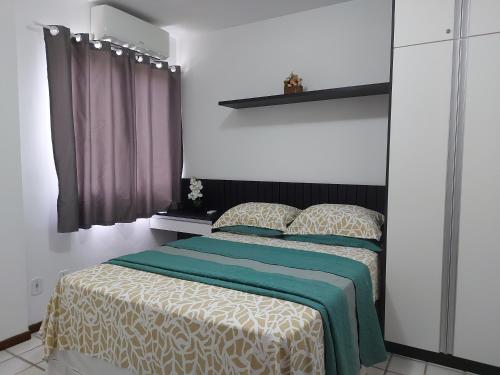 马塞约Apartamento na praia de Jatiuca的一间卧室配有一张带绿色和白色毯子的床