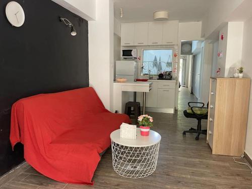 雅典A comfortable apartment to you的一间带红色床的客厅和一间厨房