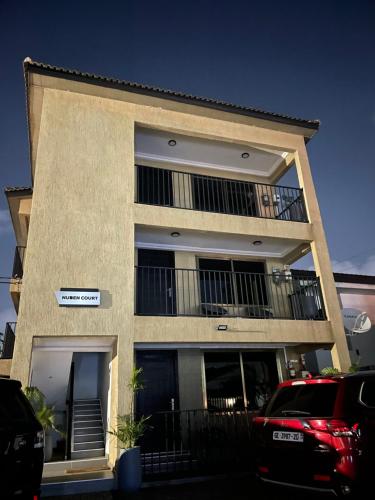 阿克拉Nuben Court-Accra的带阳台的建筑和前方的停车位