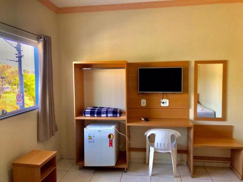 阿帕雷西达Santa Catarina Hotel的客房设有书桌、电脑和冰箱。