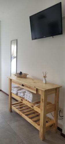 罗萨里奥Departamento monoambiente Barrio Martin的一张木桌,上面配有电视