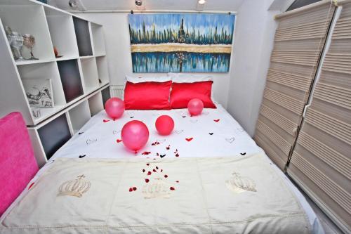 KakanjArt apartman的卧室配有粉红色气球,位于床上