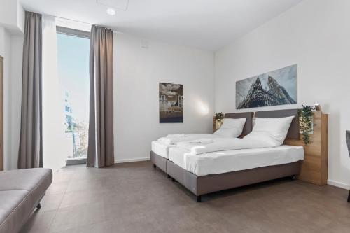 慕尼黑Flatista Homes - Aubing的一间带两张床和一张沙发的卧室