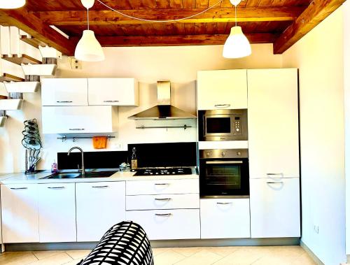 科森扎GG HOME的白色的厨房配有白色橱柜和电器