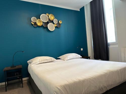马赛博斯若酒店的一间卧室设有蓝色的墙壁,墙上设有一张带帽子的床。