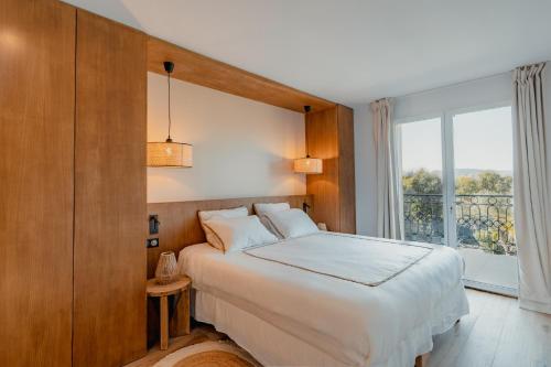 圣特罗佩Villa Joia的一间卧室设有一张床和一个大窗户
