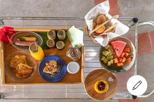 卡鲁阿鲁JasmiManga Pousada的一张桌子,上面放着一盘食物和一篮子食物