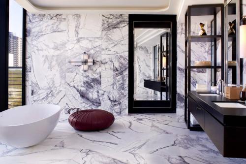 珀斯The Ritz-Carlton, Perth的浴室配有白色浴缸和大理石墙。