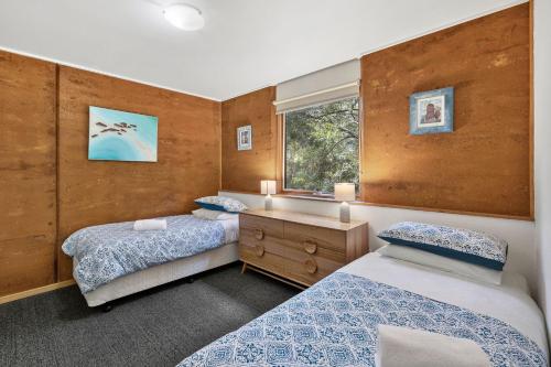 爱丽丝湾分割点别墅的一间卧室设有两张床和窗户。