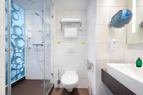 柏林柏林市东城假日酒店的浴室配有卫生间、淋浴和盥洗盆。