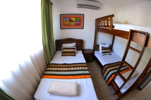 赫拉多拉Alojamiento en Playa Herradura的客房设有两张双层床和一扇窗户。