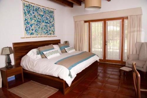 马利纳尔科Casa Pixan的一间卧室配有一张大床和一把椅子