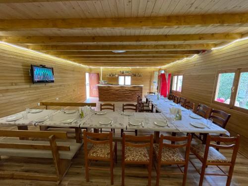 瓦勒博内Lazer Cardaku guest house的大型用餐室配有长桌和椅子