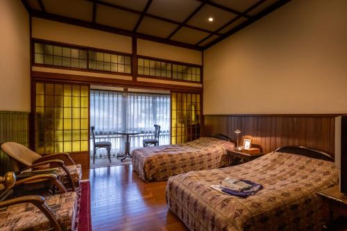 神户哈纳科亚多酒店的酒店客房设有两张床和一张桌子。