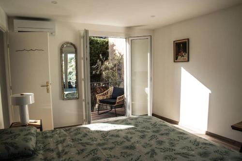马赛Les Balcons du Roucas Blanc的一间卧室设有一张床,并有通往庭院的门