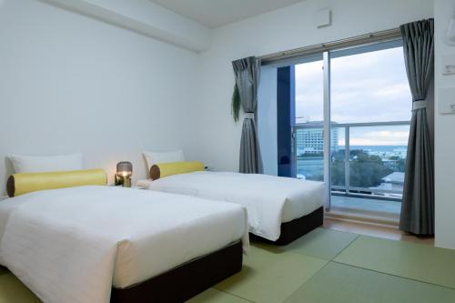 白滨クリスタルエグゼ南紀白浜2的酒店客房设有两张床和大窗户。