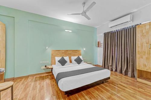 班加罗尔Upar Hotels Indiranagar的一间卧室配有一张床和吊扇