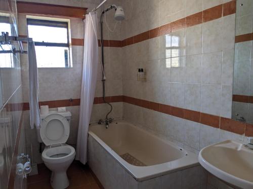 内罗毕Bliss haven Gold one bedroom fully furnished apartment的带浴缸、卫生间和盥洗盆的浴室