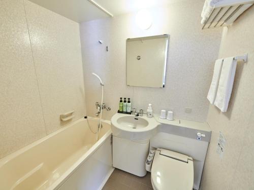 长野Hotel Courtland的浴室配有盥洗盆、卫生间和浴缸。