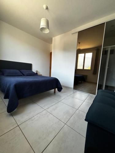 杜尔哈克Gîte San Jordi的一间卧室配有蓝色的床和镜子