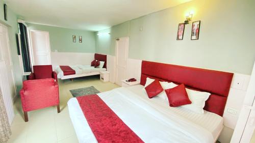 马拉里Hotel Meadows View, Near Mall Road Manali的一间卧室配有一张带红色枕头的大床