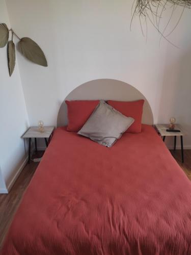 蒙特利马尔La Provinciale en Ville的一间卧室配有红色的床和两张桌子