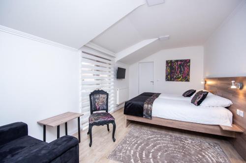 萨拉热窝Guesthouse Bebek的一间卧室配有一张床、一把椅子和一张沙发