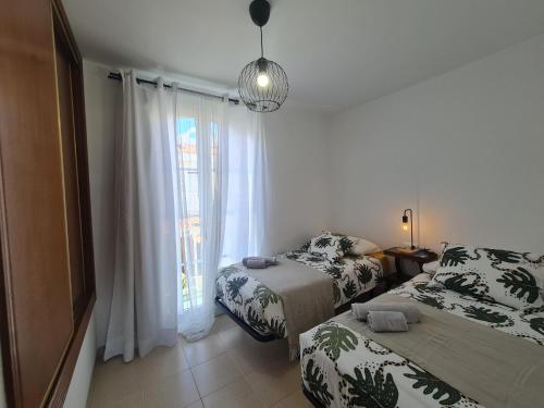 卡勒达德福斯特We Fuerteventura的一间卧室设有两张床和窗户。