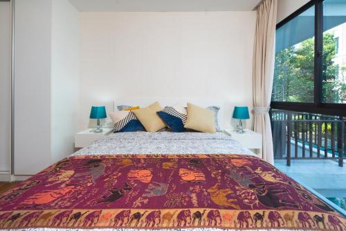拉威海滩The Title Rawai West Wing Pool View Suite的一间卧室设有一张大床和一个窗户。
