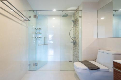 拉威海滩The Title Rawai West Wing Pool View Suite的一间带玻璃淋浴和卫生间的浴室