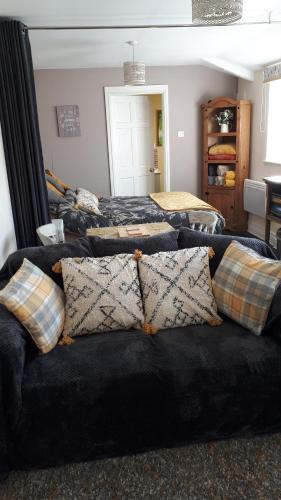惠特比Thyme Cottage的客房设有两张床和一张带枕头的沙发。