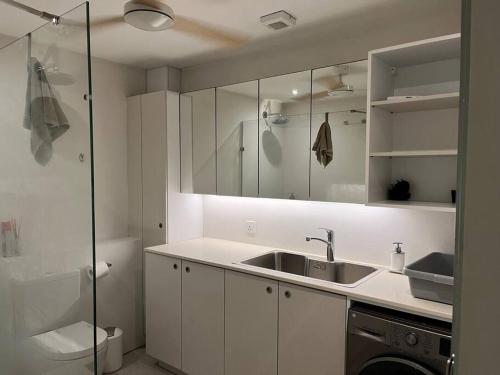 塔马兰Beachfront Apartment的白色的厨房设有水槽和淋浴
