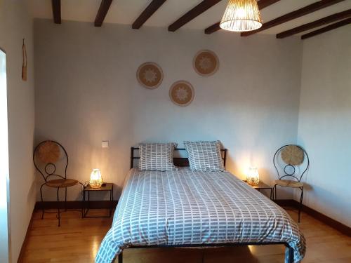 PolignacMaison du Soleil chez Isa的一间卧室配有一张带两把椅子和两盏灯的床