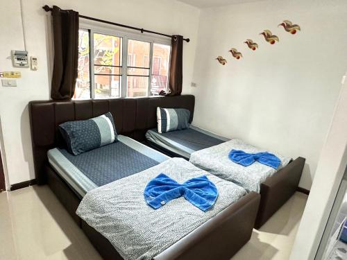 Ban Nong Ben (1)凯乐度假村的一间卧室配有两张带蓝色弓的床铺。