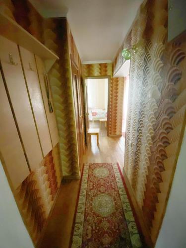 (( Turksib ))Квартира напротив Аэропорта的一间设有走廊、地毯和桌子的房间