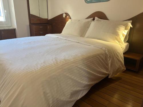 蒙特罗索阿尔马雷Elegant apartment with sea view的一张白色大床,配有白色床单和枕头