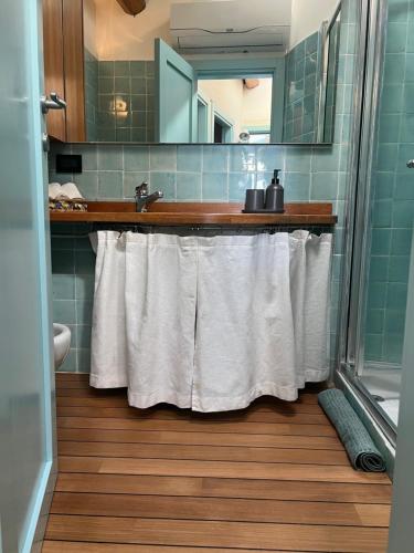 蒙特罗索阿尔马雷Elegant apartment with sea view的浴室配有水槽和带白色毛巾的淋浴