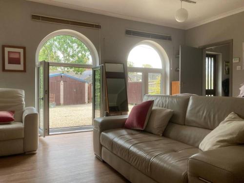 CassingtonSecret little hideaway - with proximity to Oxford的带沙发和开放式门的客厅