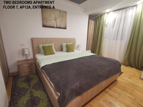 布加勒斯特Black and White Apartments的一间卧室配有一张带绿色窗帘的大床