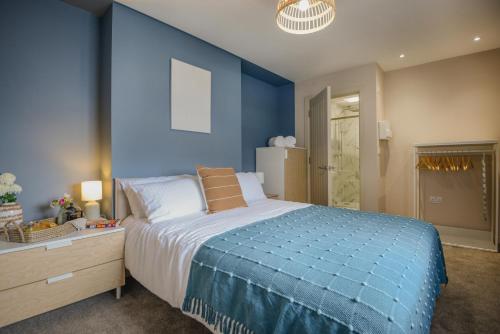 普里茅斯Apartment One - King Bed - Free Private Parking - by Ocean City Retreats的一间蓝色卧室,配有一张大床和一个梳妆台