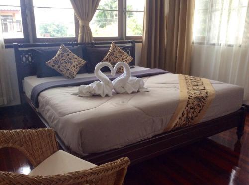 曼谷小村自然祝福度假酒店的卧室里床边的两只天鹅