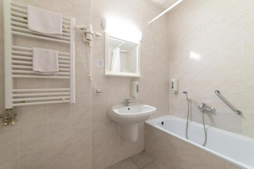 布达佩斯Gartner Hotel的浴室配有盥洗盆、卫生间和浴缸。