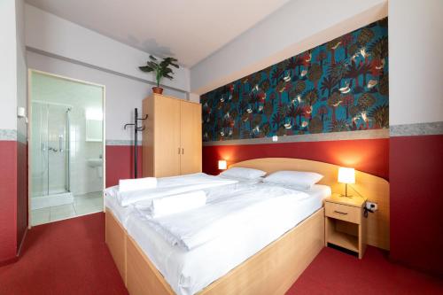 布达佩斯Gartner Hotel的一间带大床的卧室和一间浴室