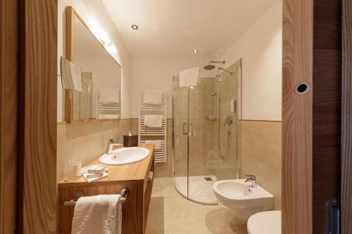 圣克里斯蒂娜Family Hotel Posta的带淋浴、盥洗盆和卫生间的浴室